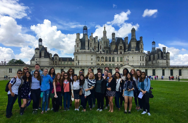 Group of students posing in front of French castle.