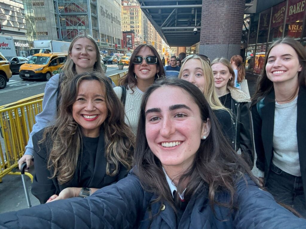 nine students and their professor on the sidewalk in New York City