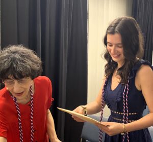 woman on left and young woman on right looking at paper in hand