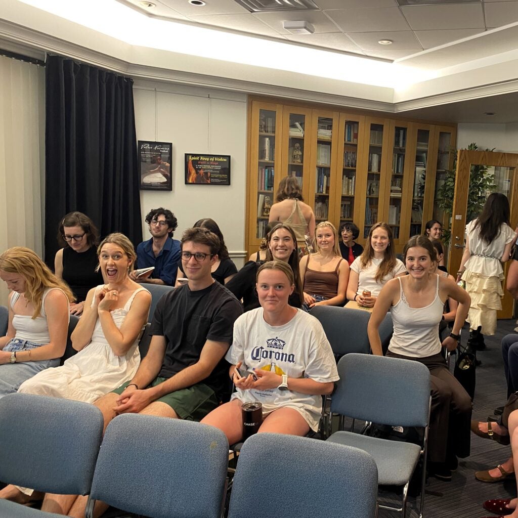 several people in chairs as audience in room