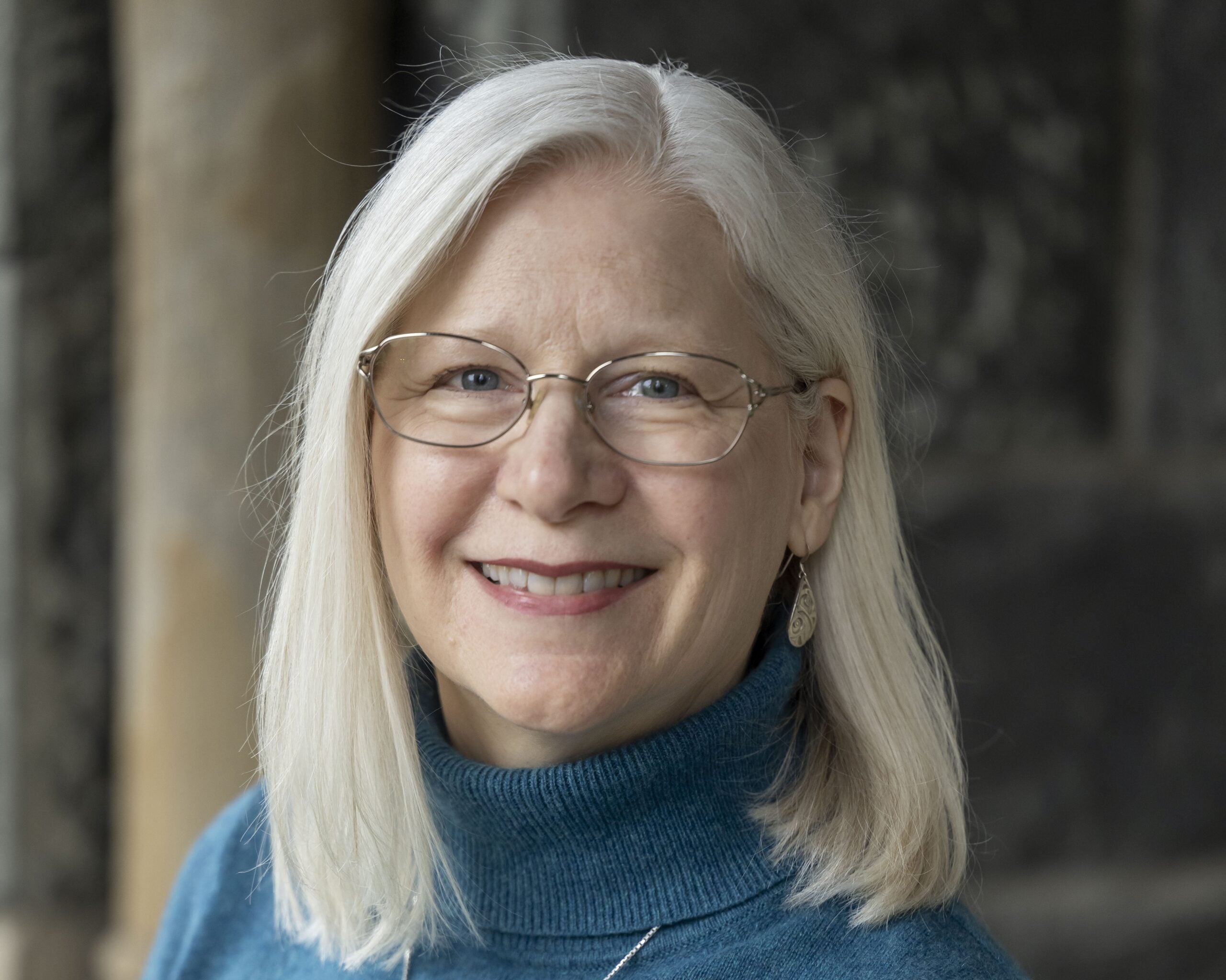 light-skinned woman with white hair and glasses
