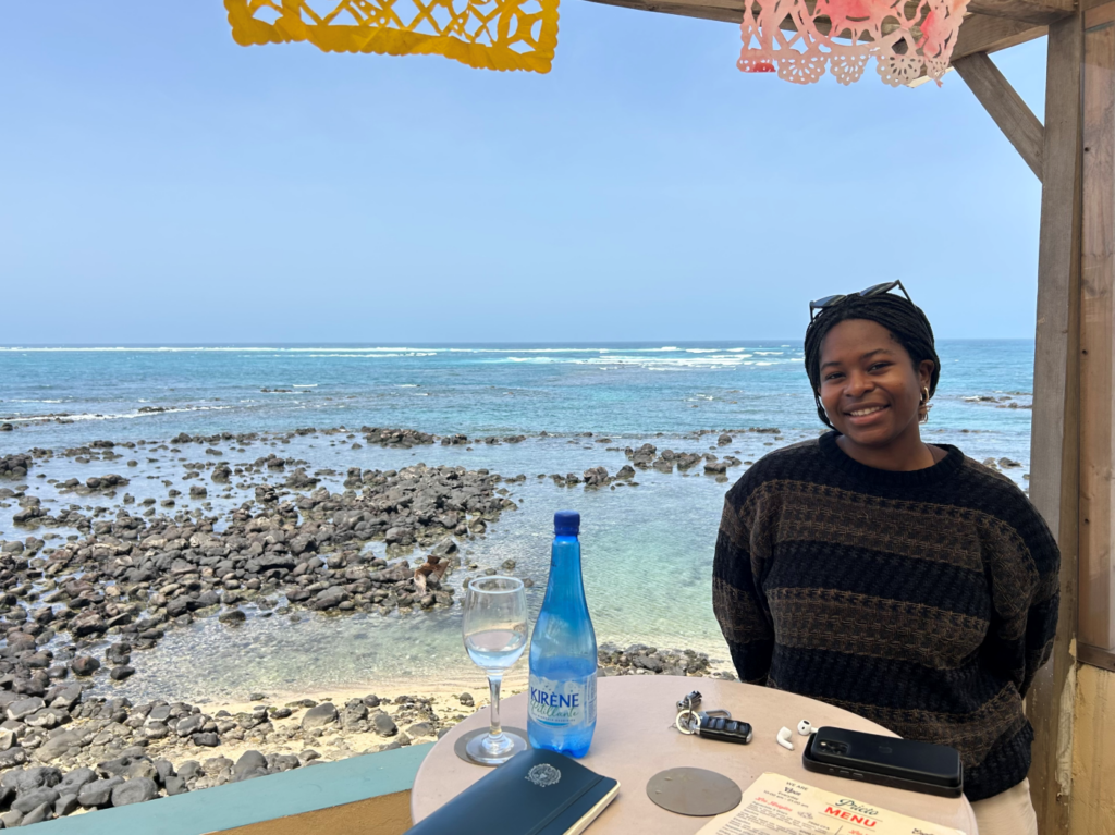 Black woman at table on the beach